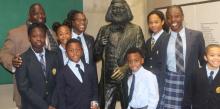 George E. Thornton, Sr., principal of the Dupont Park Adventist School, and eight students (left of the statue) Imani Yates, Simone Scott, Ayanna McInnis, Christopher Henderson, (right of the statue) Chase McClure, Jaffe Watkins, Dorian Donovan and Lawrence Talbert stand next to a Frederick Douglass statue.